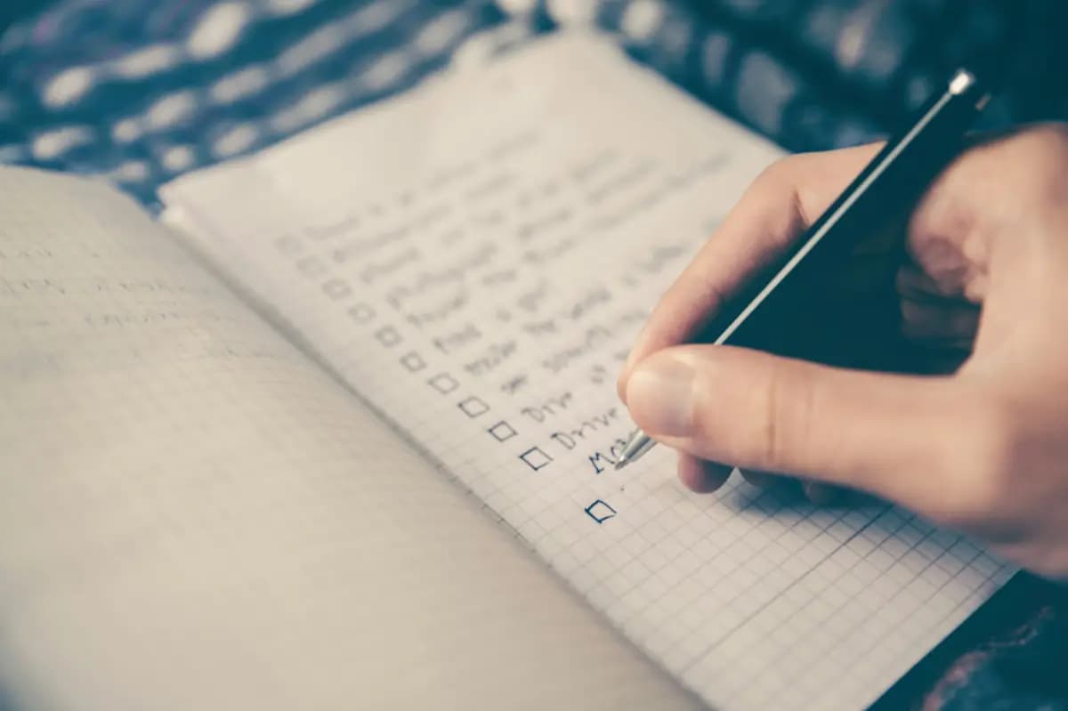 A hand checking boxes on a checklist